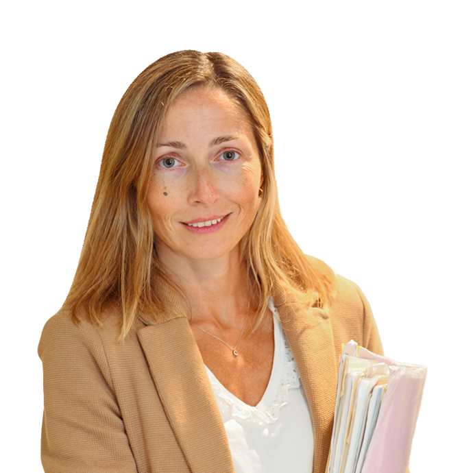 A woman with light brown hair wearing a tan blazer and white top smiles whilst holding a stack of folders and papers, standing against a white background.